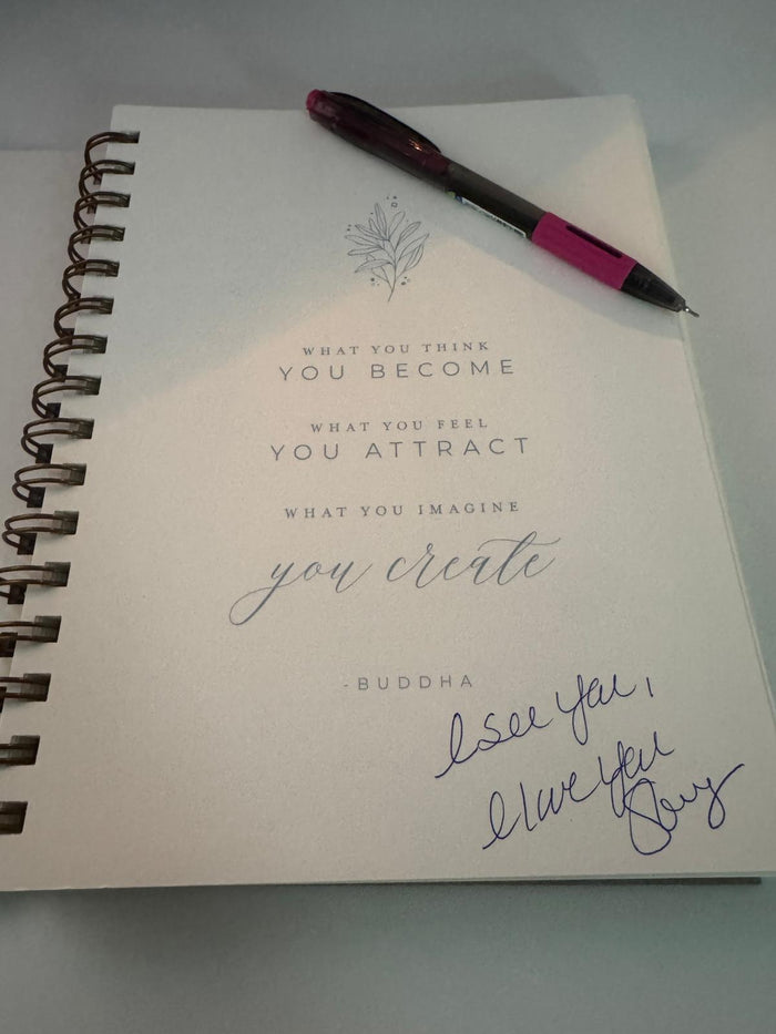 White journal and pen on a soft surface, captured for A Love Letter to Women blog by The Her Mood Podcast — a reminder of reflection, resilience, and womanhood.